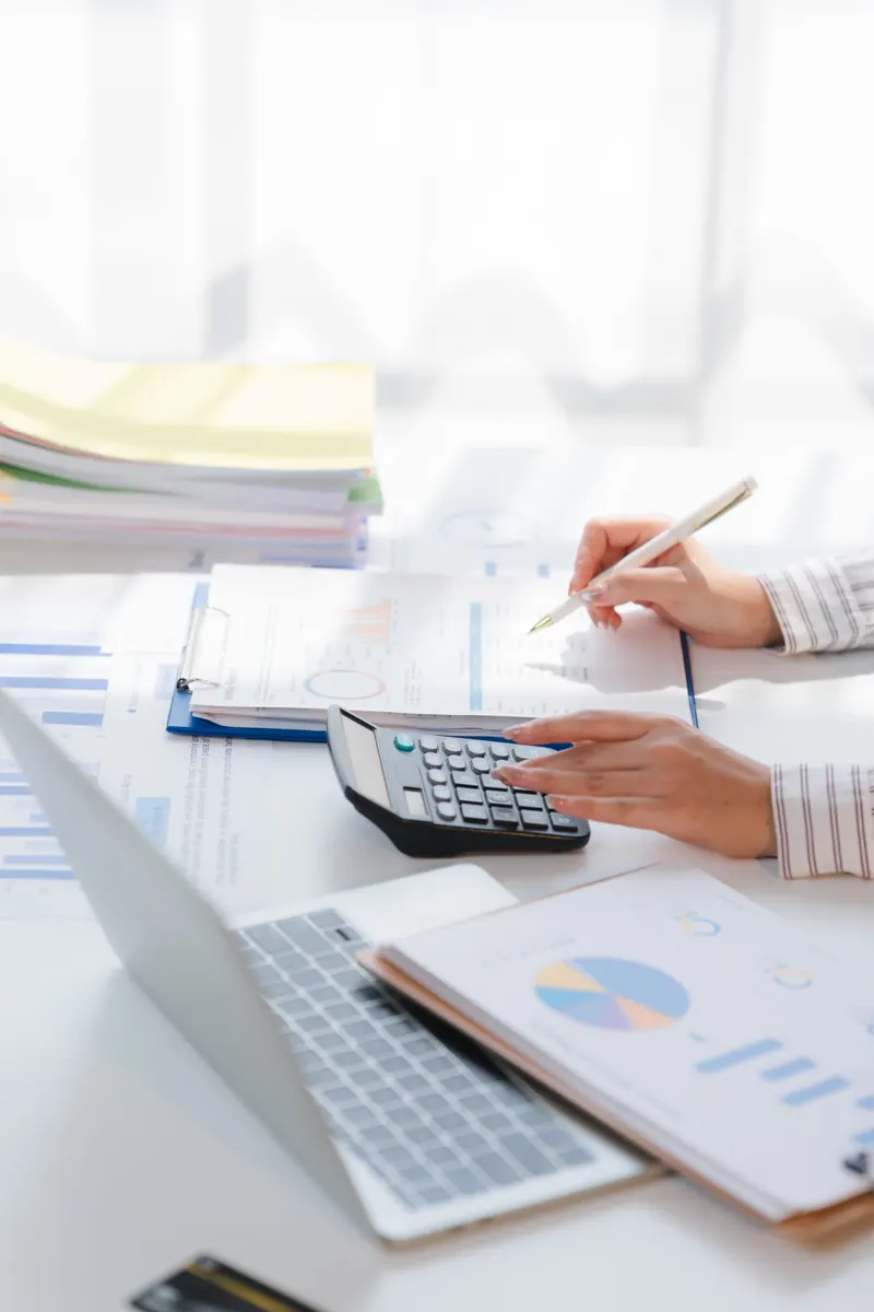 An accountant working through financial statements with a calculator
